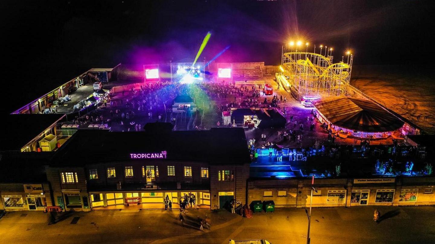 A bird's eye view of the Tropicana with colourful lights and many people enjoying a night out.