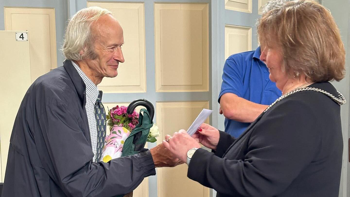 Robin Farmer receiving a bunch of flowers from Ludlow Town Council