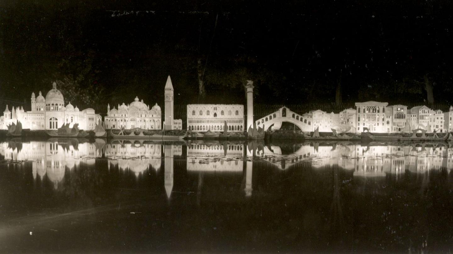 A black and white image showing a model of the Venice skyline at the light festival. The skyline is reflected in a pond.