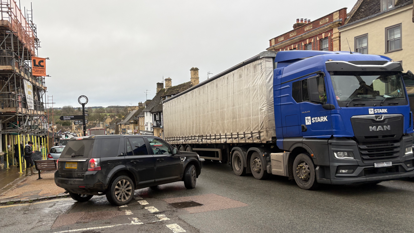 An SUV pulls out of Sheep Street onto High Street, Burford, just as a lorry is passing