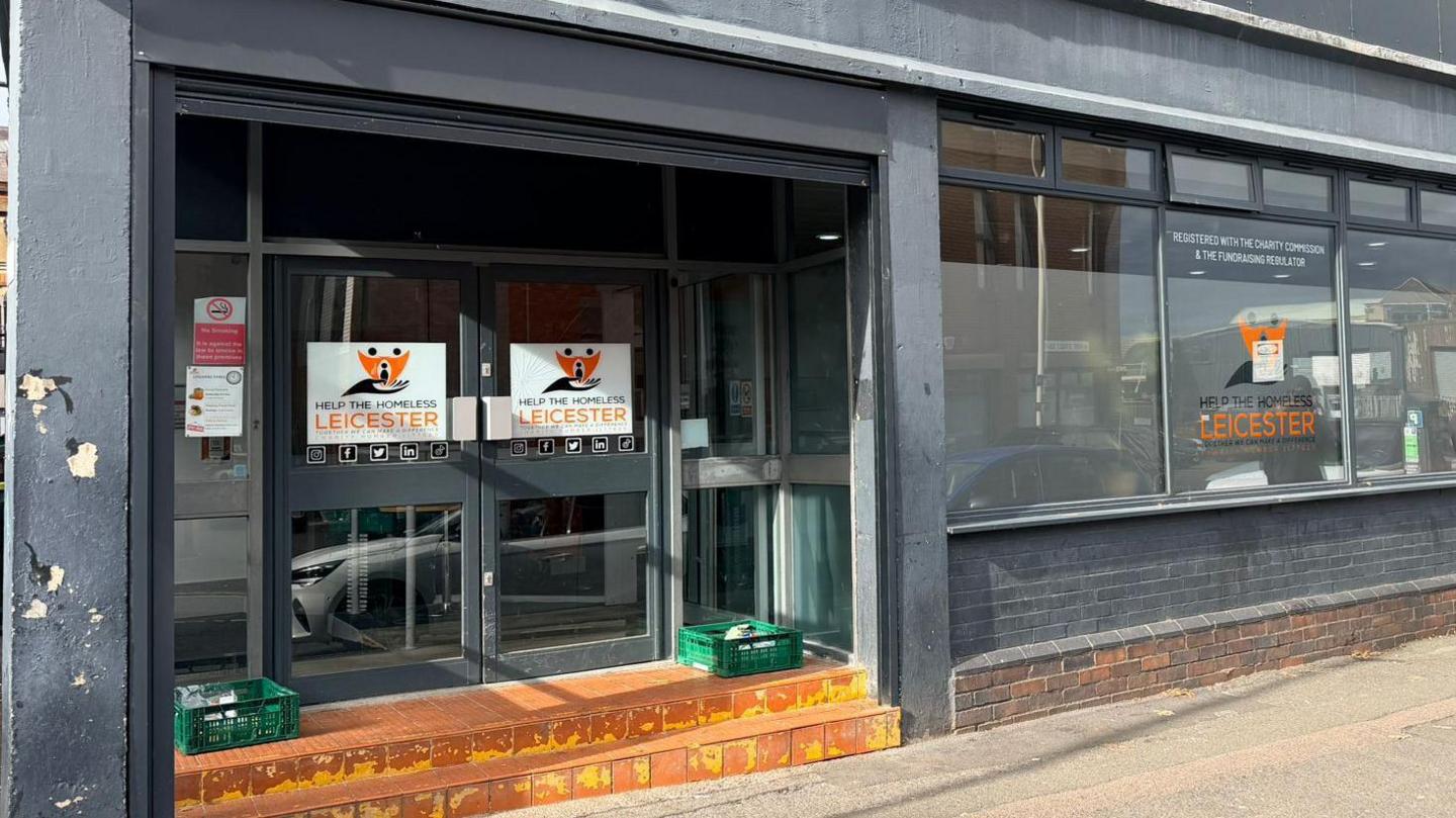 Front of a building with two doors with sign on the doors and window