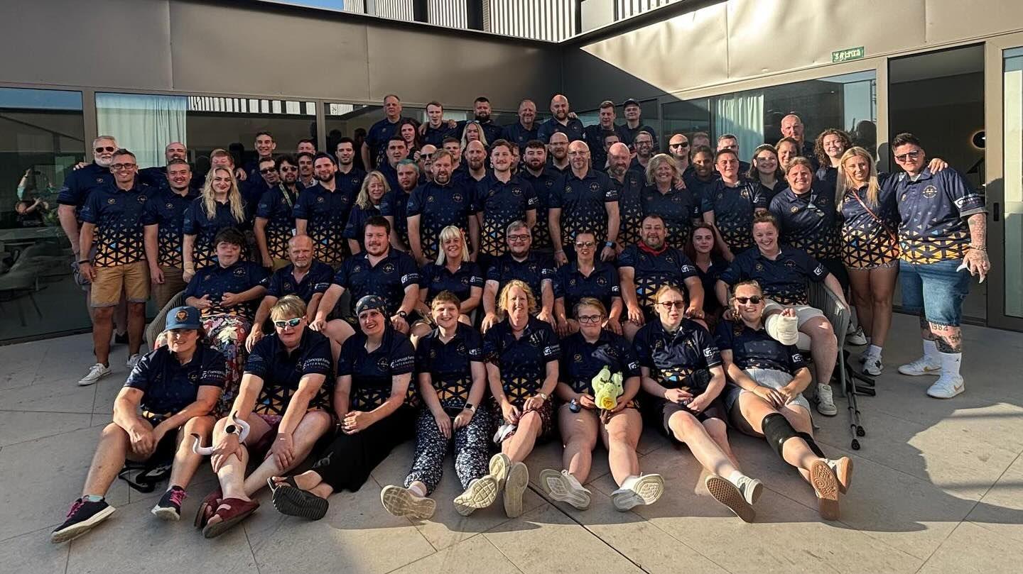 Worcester's men's and women's mixed ability teams are posing for a group photo. They are all wearing the navy and gold club shirts. 