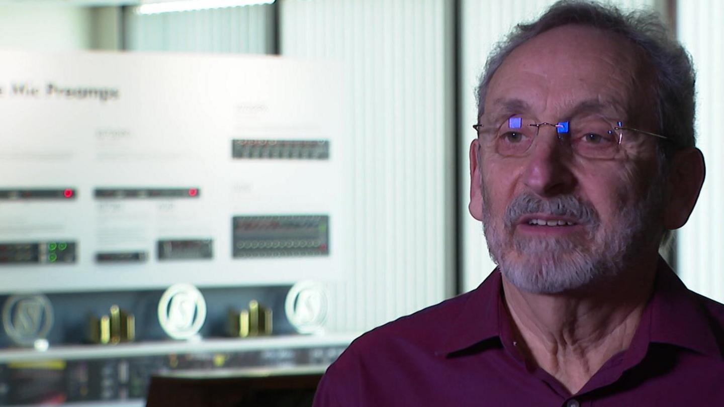 AMS Neve founder and director Mark Crabtree in his office showing trophies and sound system equipment in the background