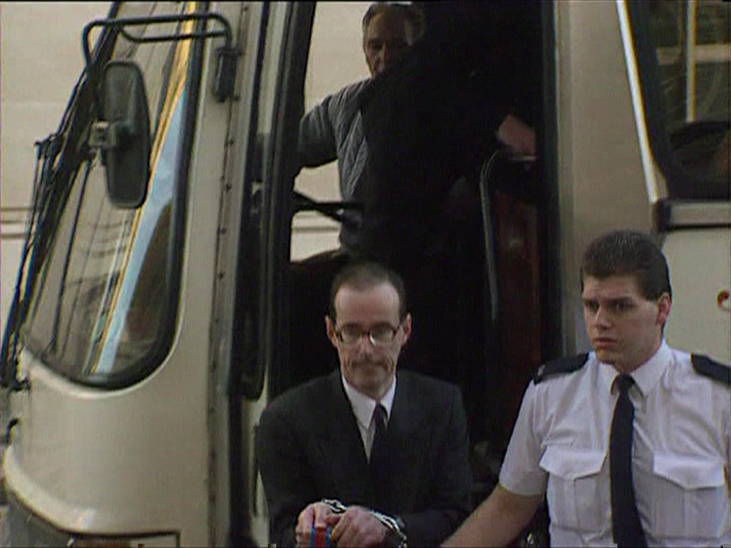 Jonathan being led into court in handcuffs