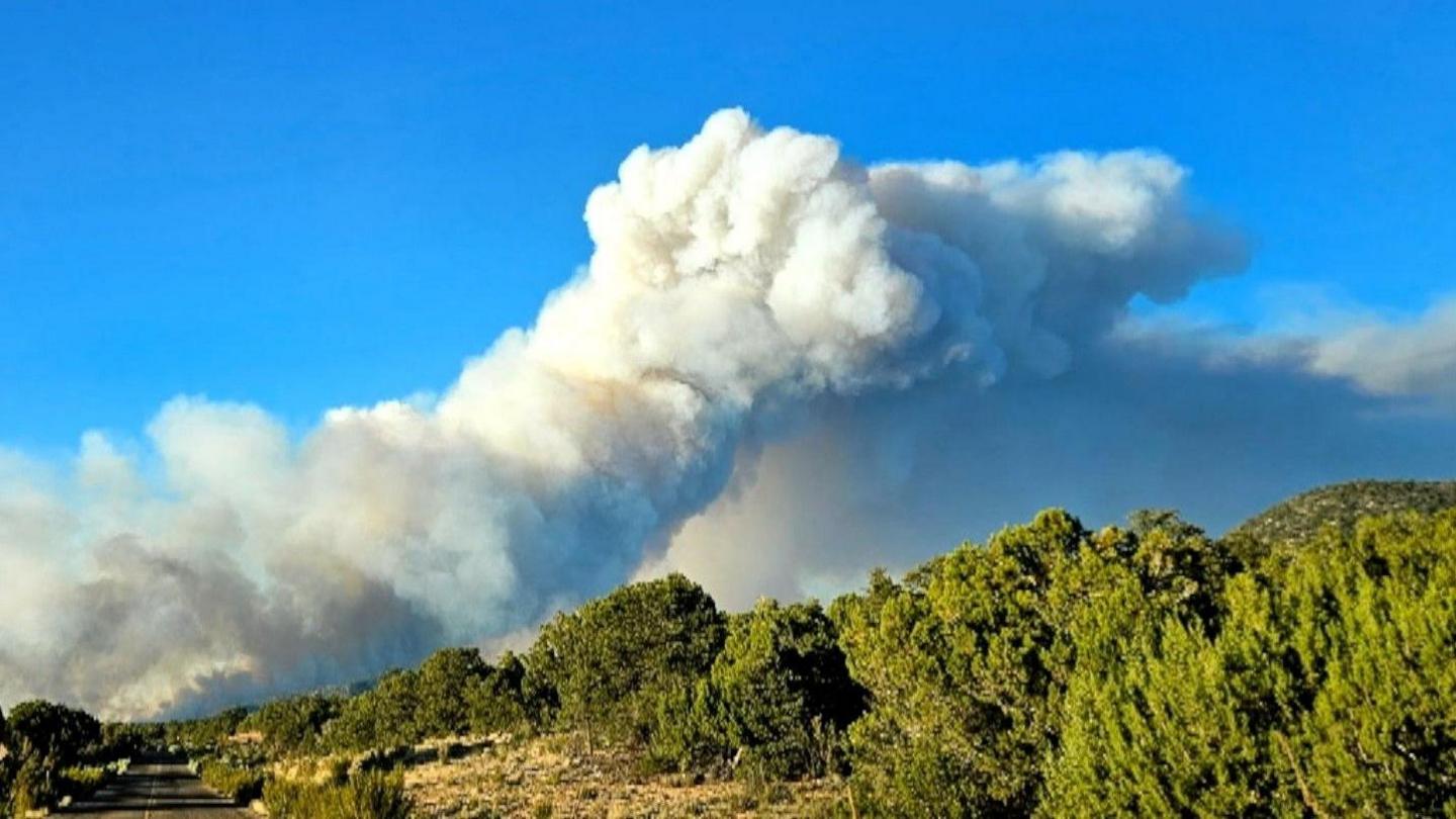 Picture of smoke rising over the mountains at Arizona fire with a blue sky in the background
