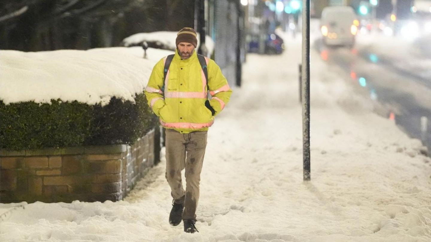 Man walks in snow in Bradford