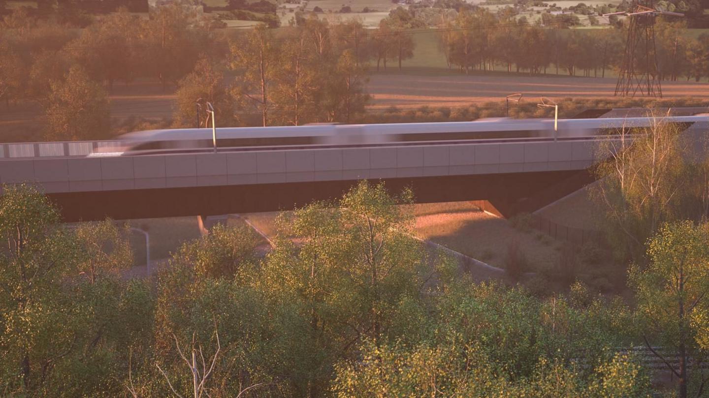 Artist's impression of HS2 Small Dean Viaduct . It shows a blurry speeding train part-way over a bridge surrounded by trees, with fields and more trees beyond.