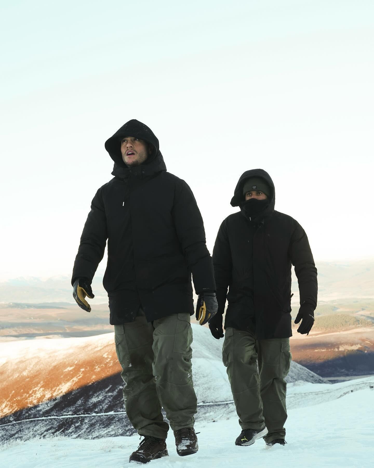 Two men walking on snow covered hills