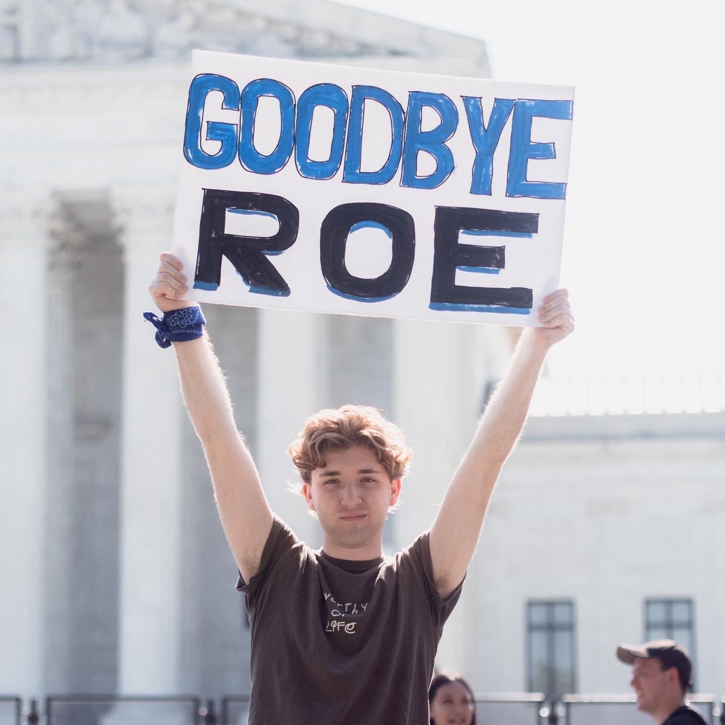 Person holding 'Goodbye Roe' sign