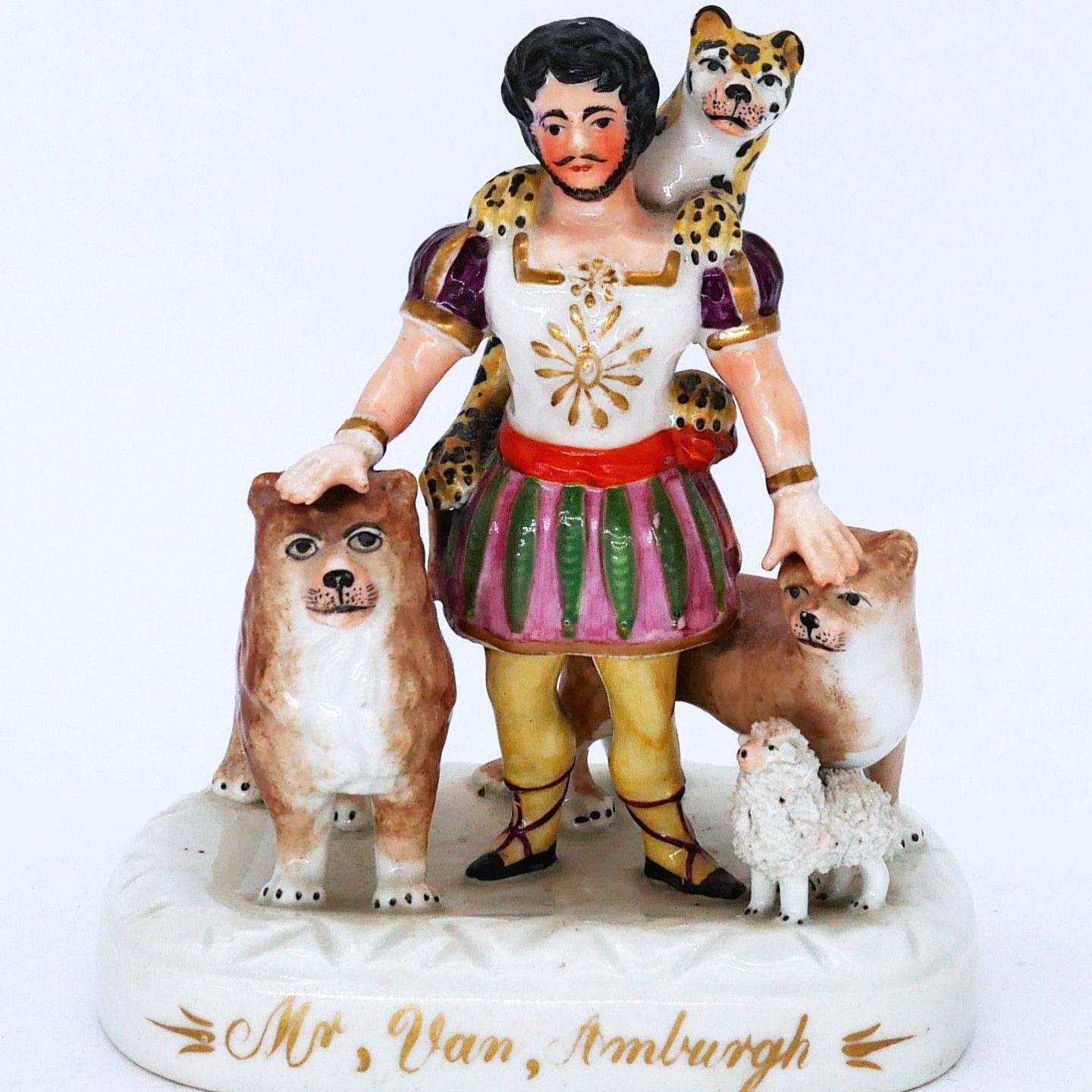 A Staffordshire pottery figure of a colourfully-dressed lion tamer with a leopard round his neck, lions at his side and a lamb at his feet