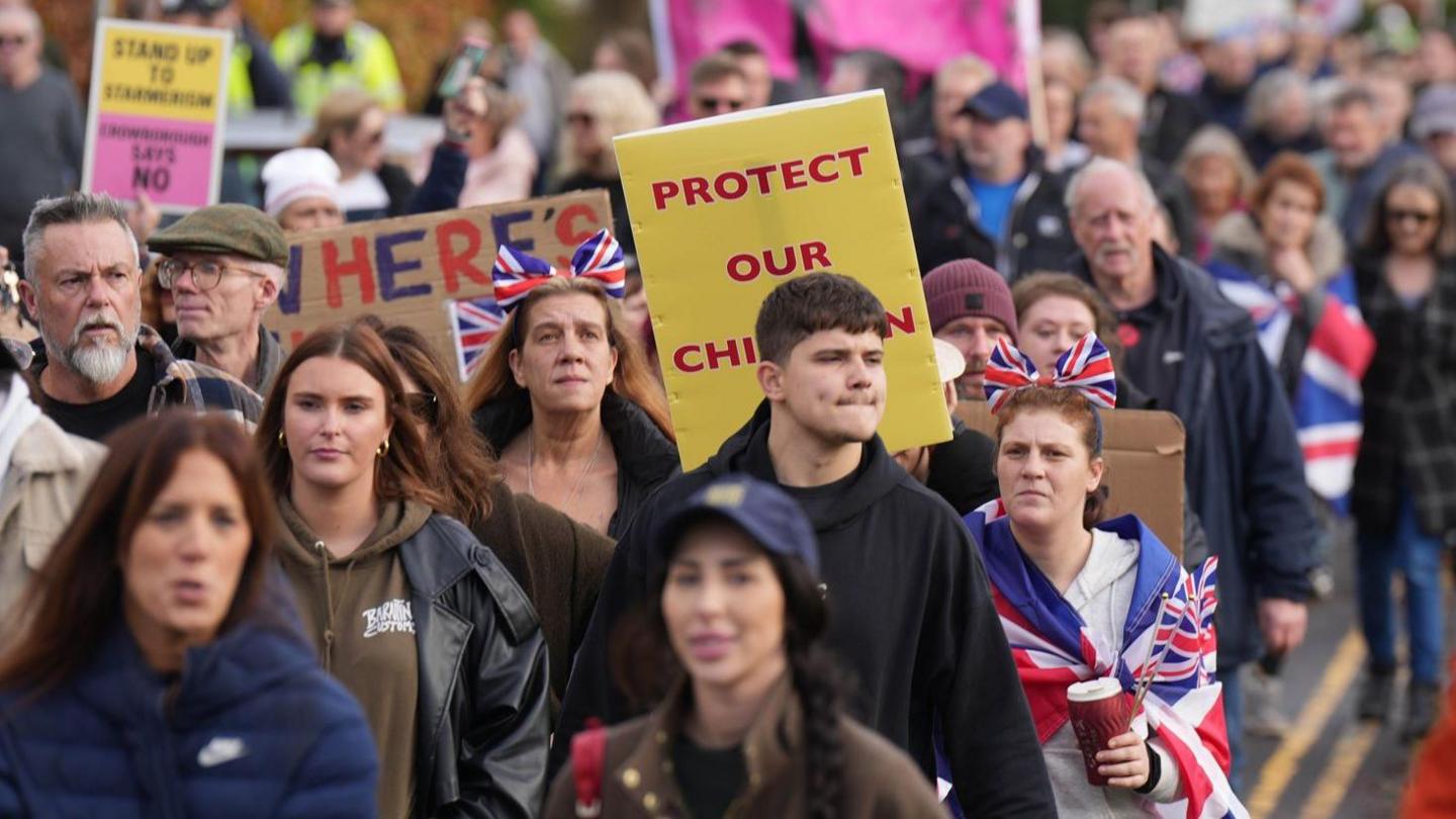 People standing with Union Jack flags and placards.