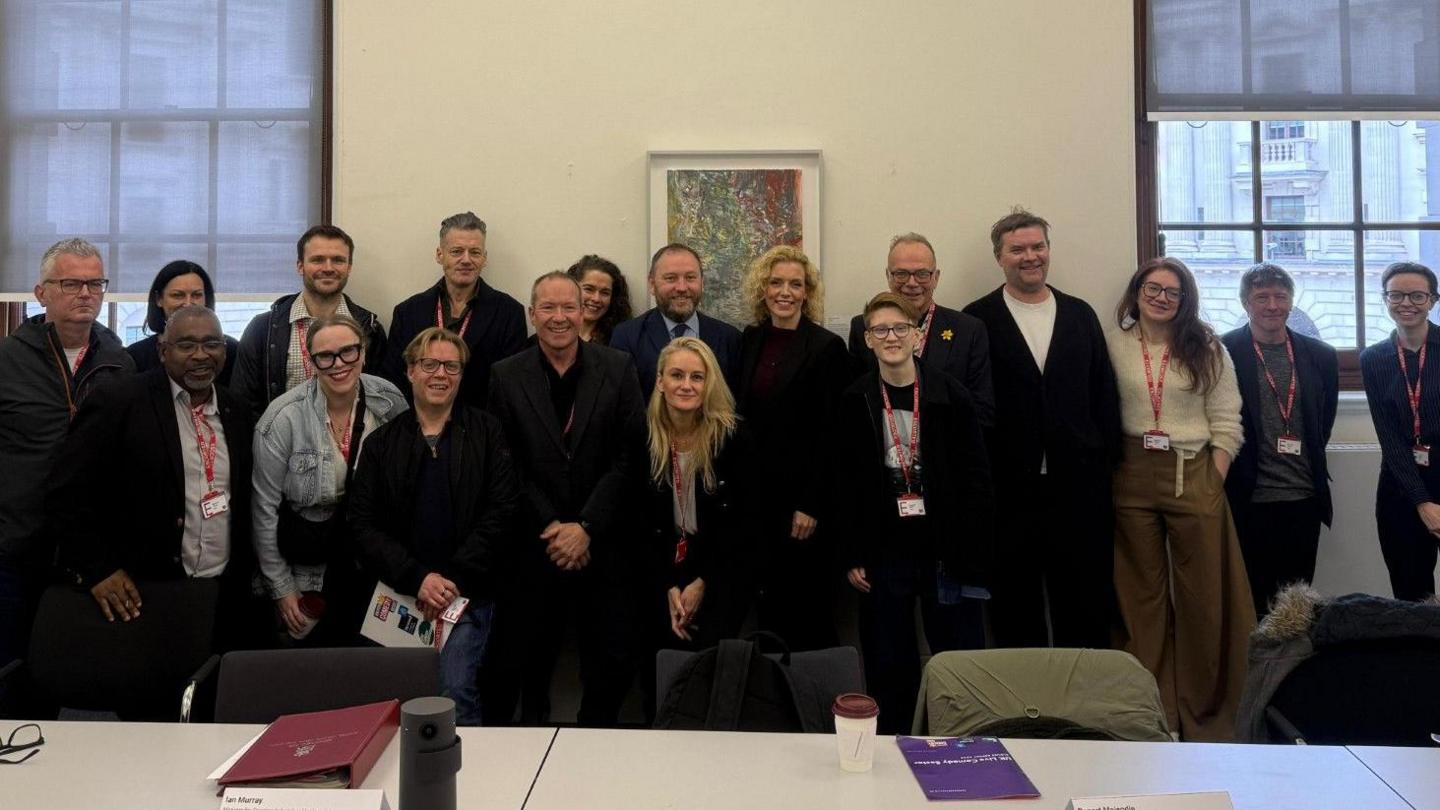 Several members of a delegation from the comedy sector stood in a line posing for a photo with minister Ian Murray.