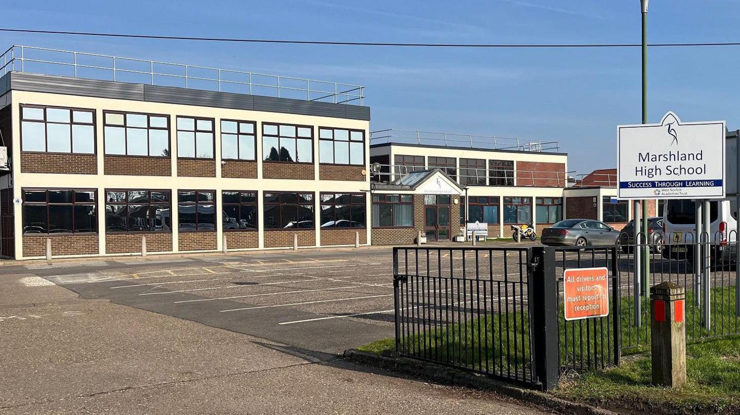 External view of Marshland High School. It is a brick building with lots of windows and a sign stating Marshland High School - success through learning. 