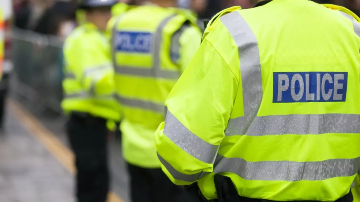 A police officer wearing a high-vis jacket which reads POLICE on the back. No faces can be seen.