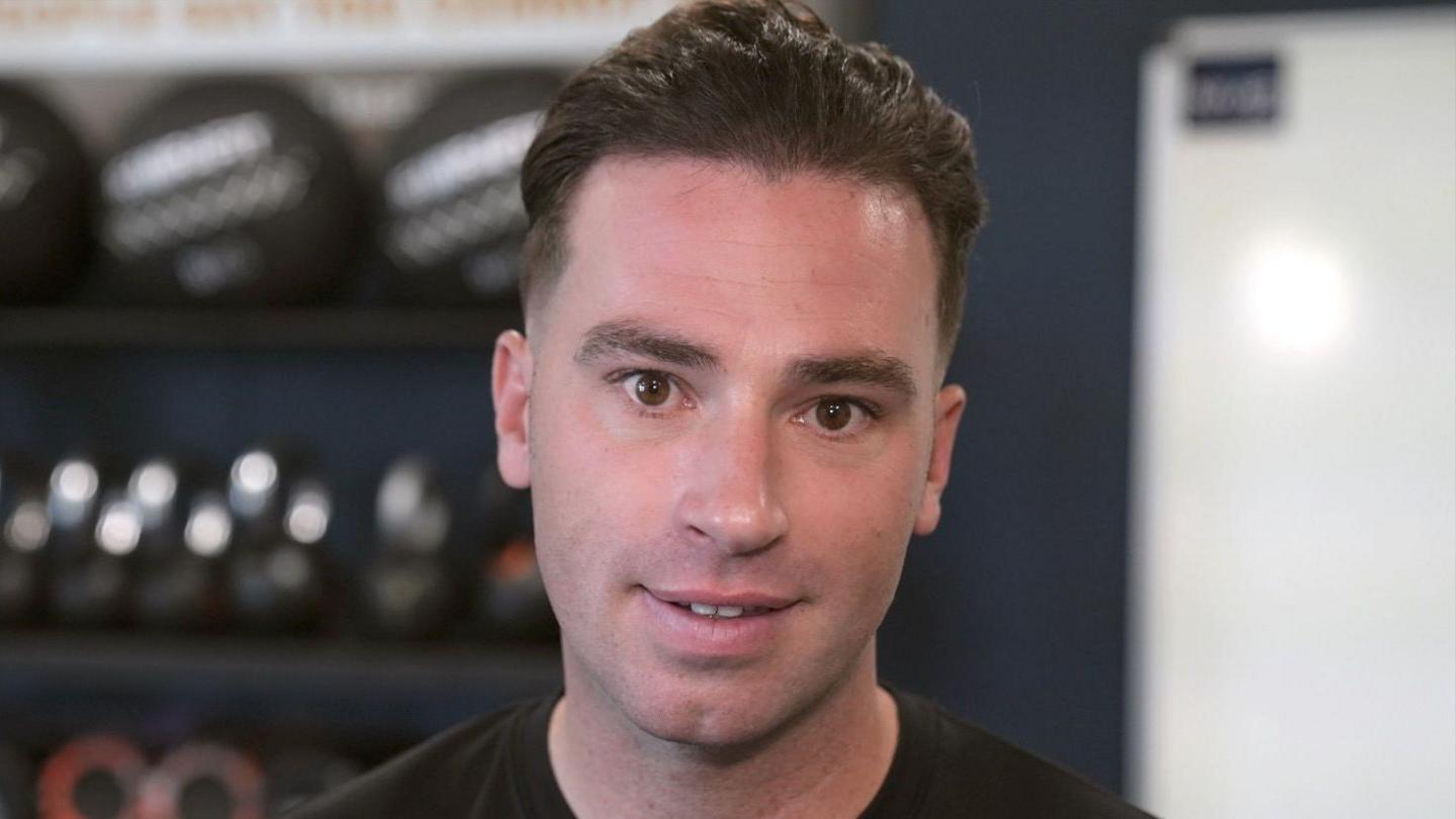 The Army's physical training instructor James Battle stands in front of some weights.