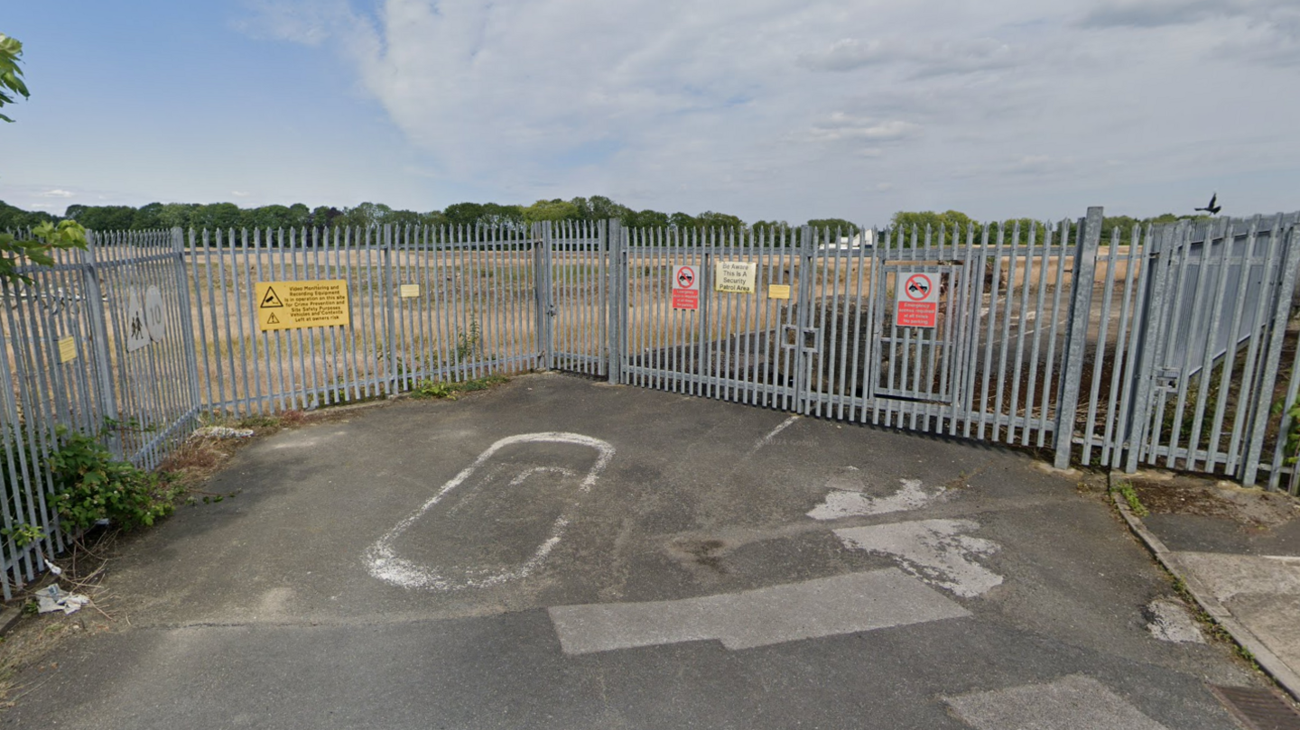 A derelict area surrounded by a metal fence.