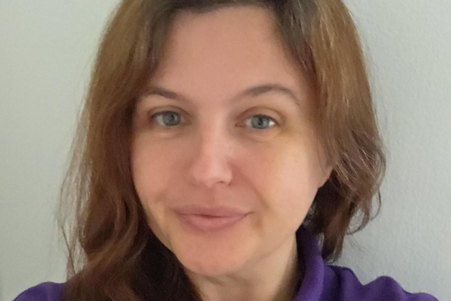 A head shot of a woman with brunette hair, looking into the camera.