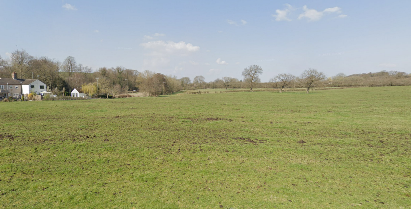 Open fields viewed from the edge of Eastwood with a white house on the left and trees in the far distance