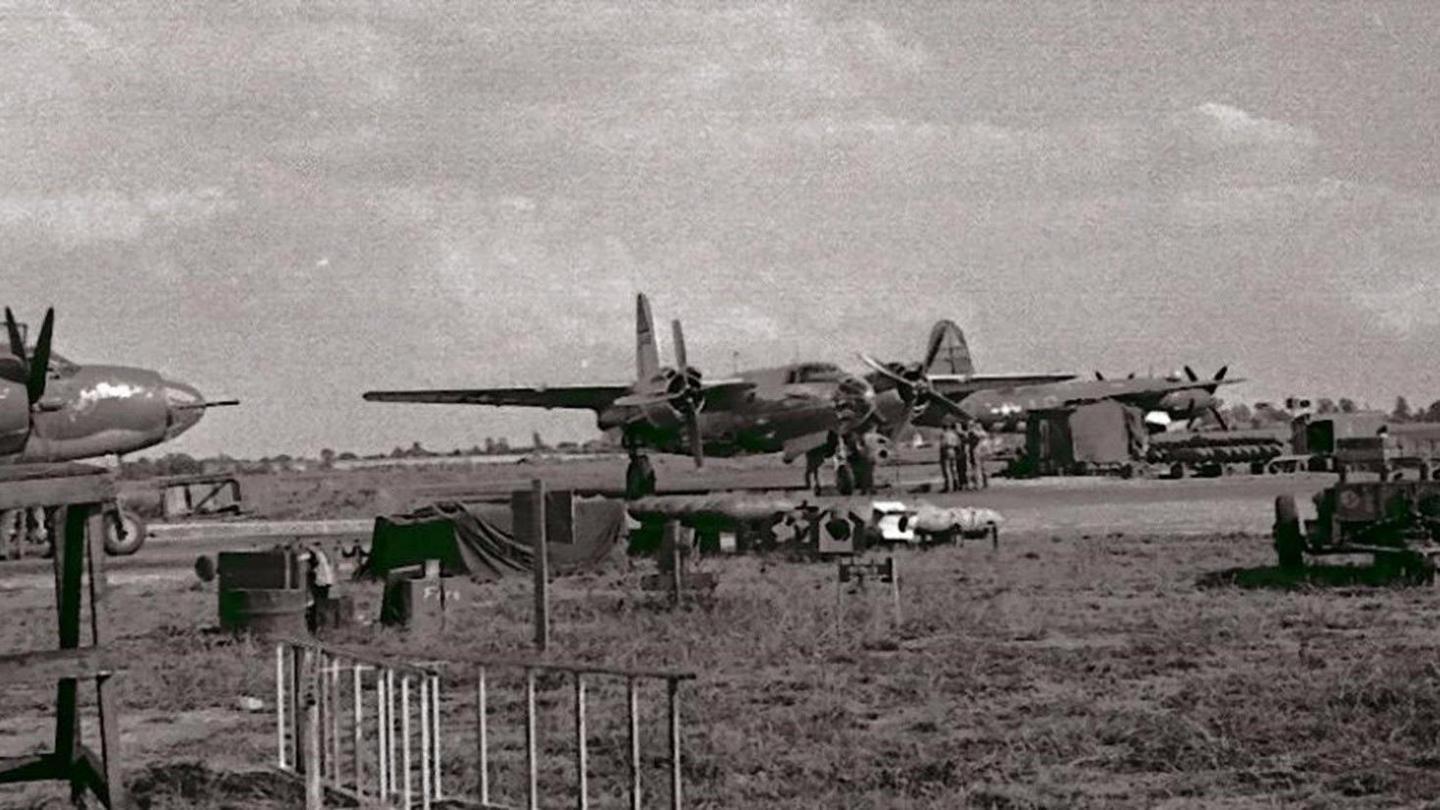 A black and white photo of planes on an airfield.