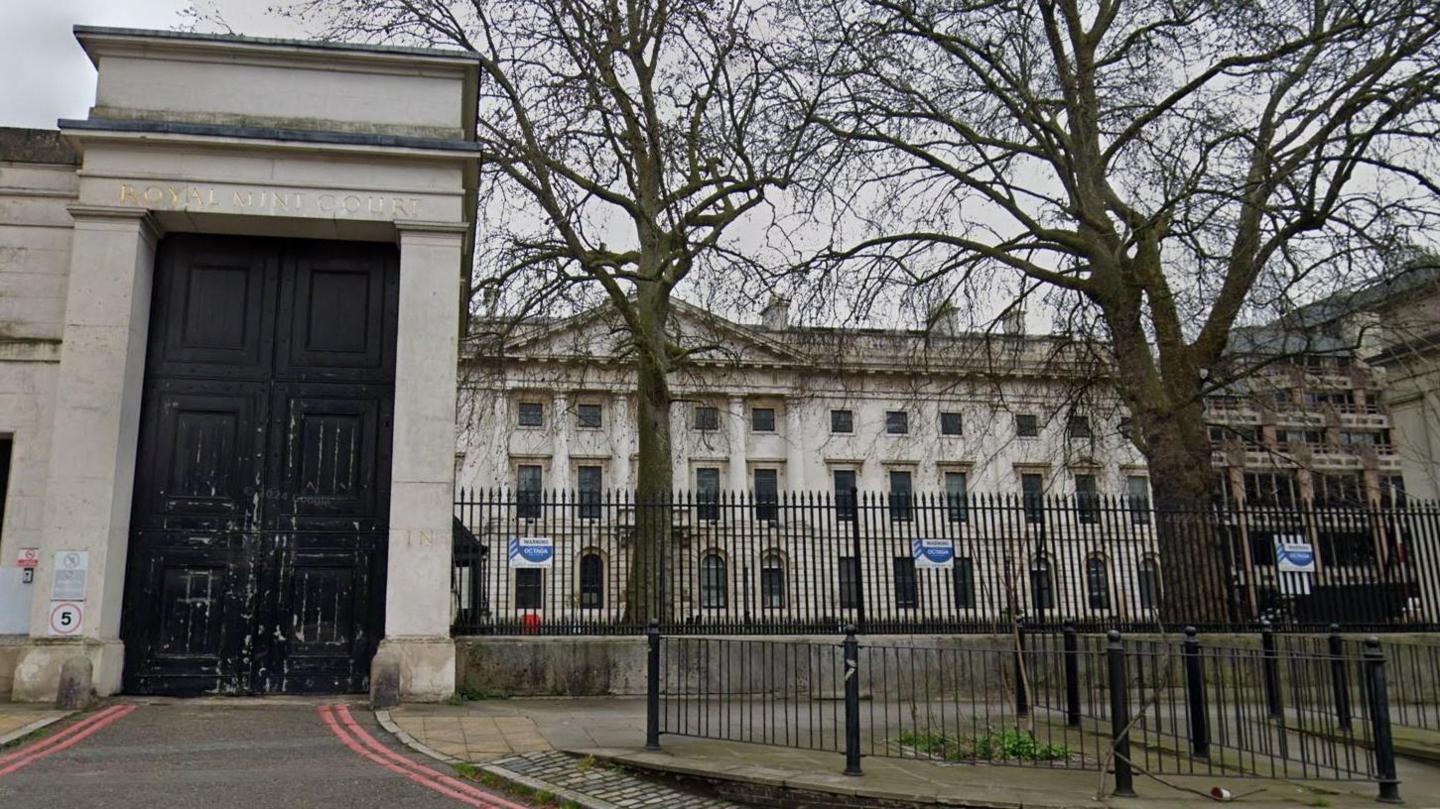 Royal Mint Court exterior with two trees and black railing either side of a main entrance with a black door beneath the words 'Royal Mint Court'