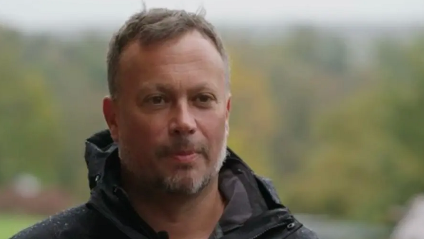 Mark Habben wears a black raincoat as he looks into the distance