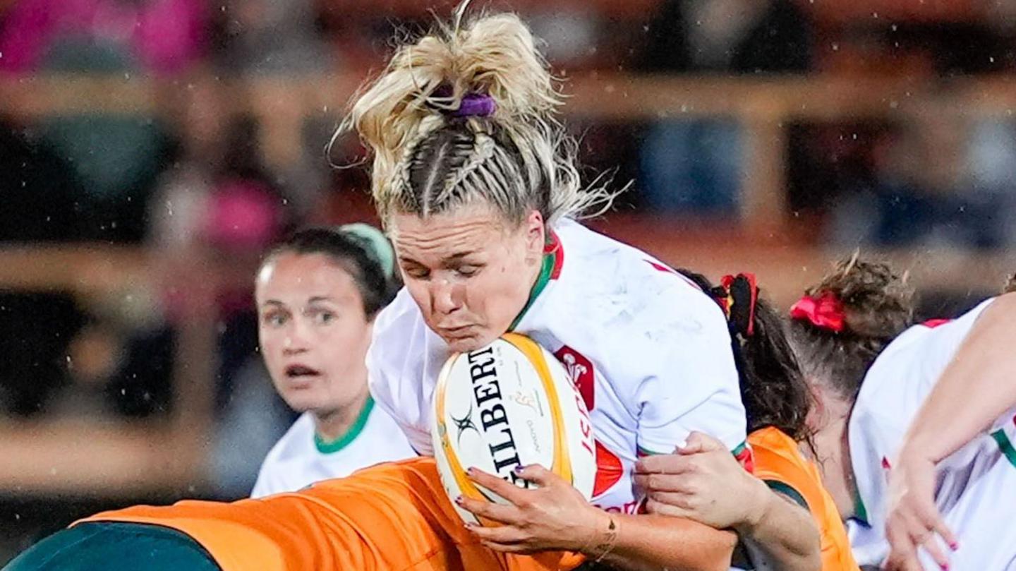 Alex Callender is tackled whilst holding the ball