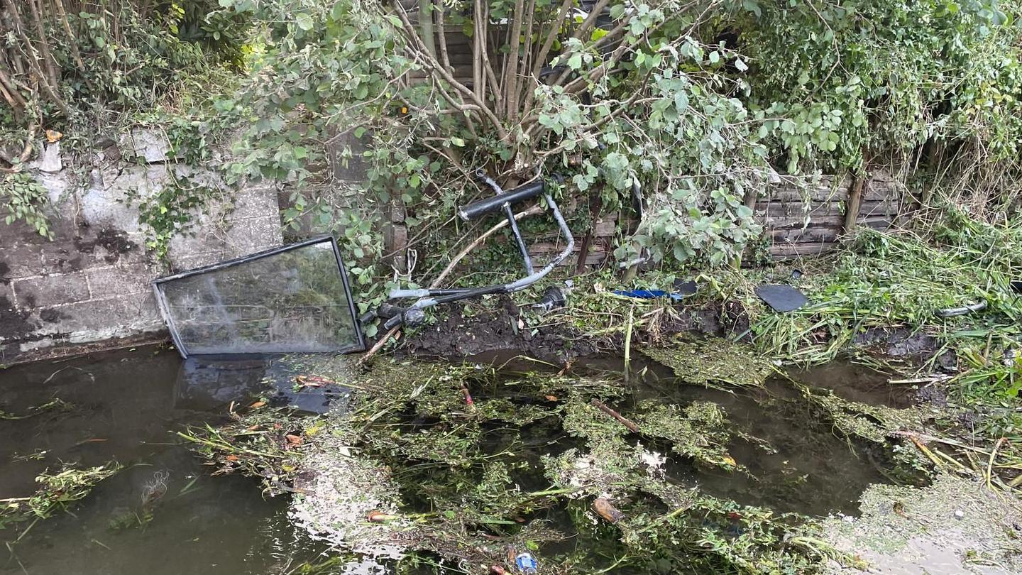 River with debris from bus following crash floating and submerged in the water