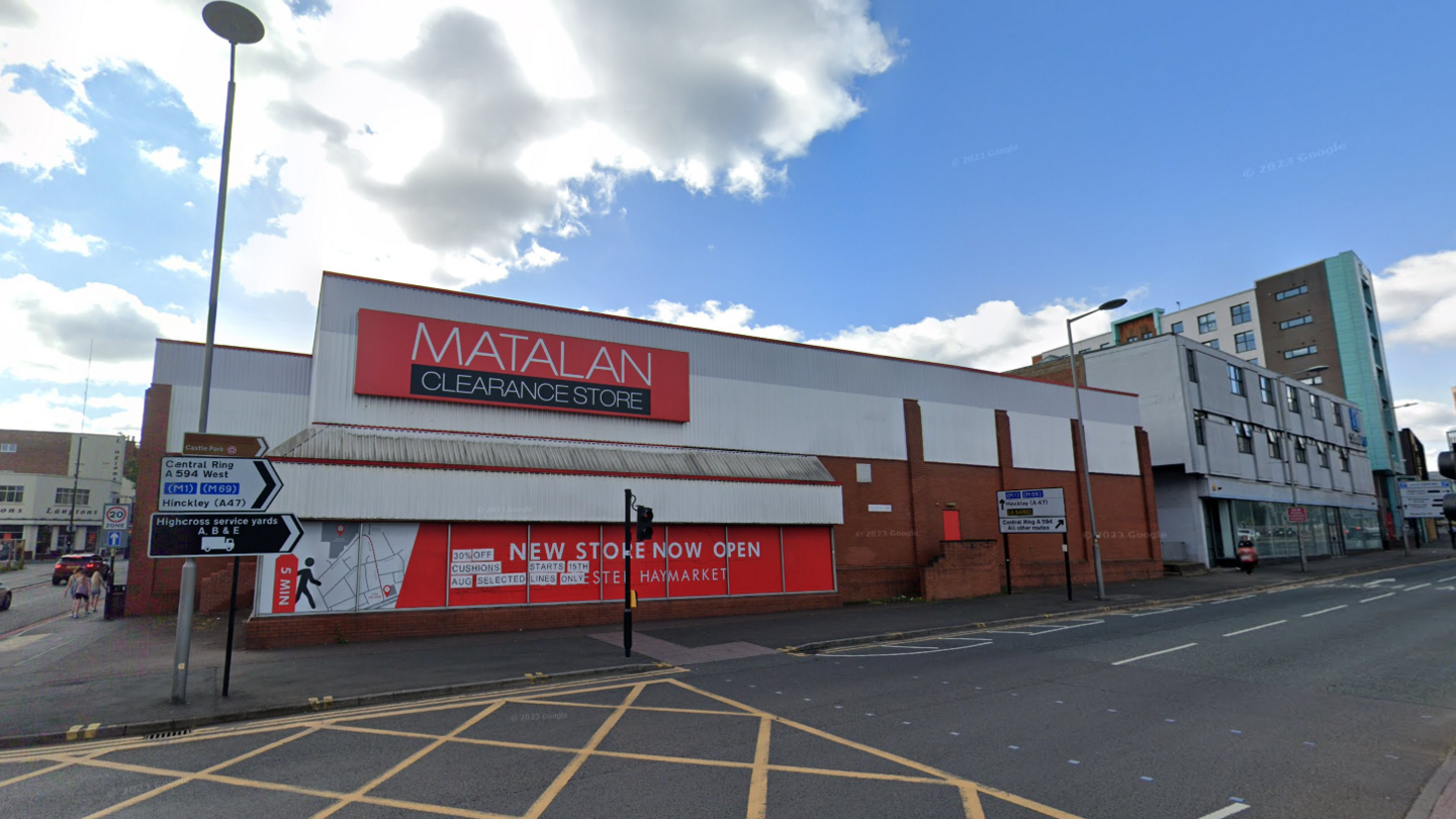 A large single-storey Matalan store with a red shop front at the side of a main road