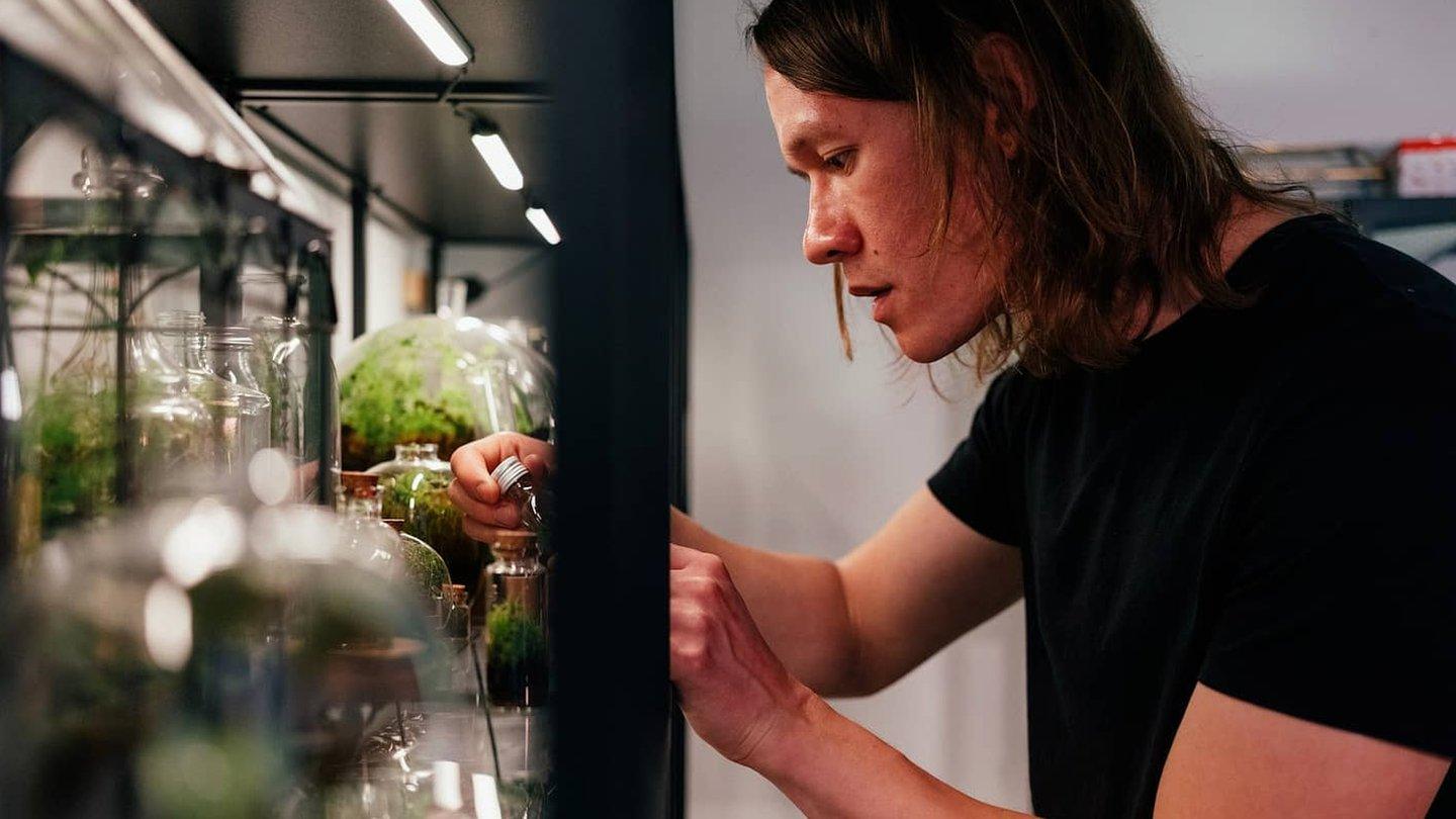 Ben Newell putting plants into glass containers