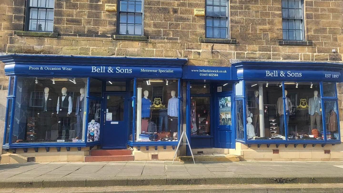 The front of Bell and Sons, a large shop with a blue front in a Georgian building. 