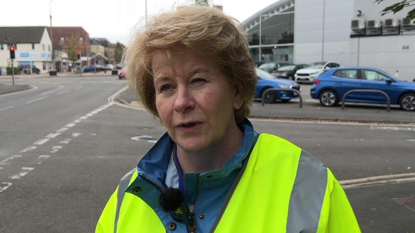 Councillor Lesley McLean, who has short, blonde hair, is wearing a hi-vis jacket and has a light blue waterproof coat under that