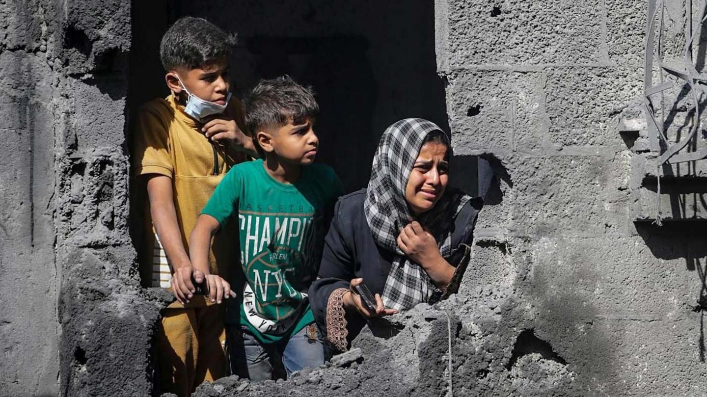 File photo showing Palestinian children looking out from their family's destroyed house following an Israeli air strike, in Shati refugee camp, northern Gaza (29 October 2025)