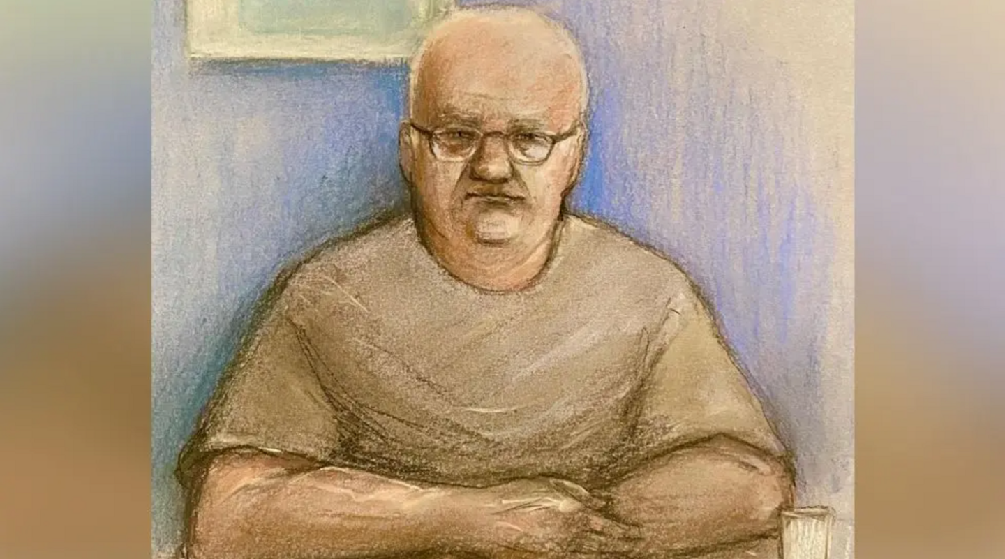 A court sketch of Steve Wright - a bald while male with glasses wearing a T-shirt, and with his arms crossed. 