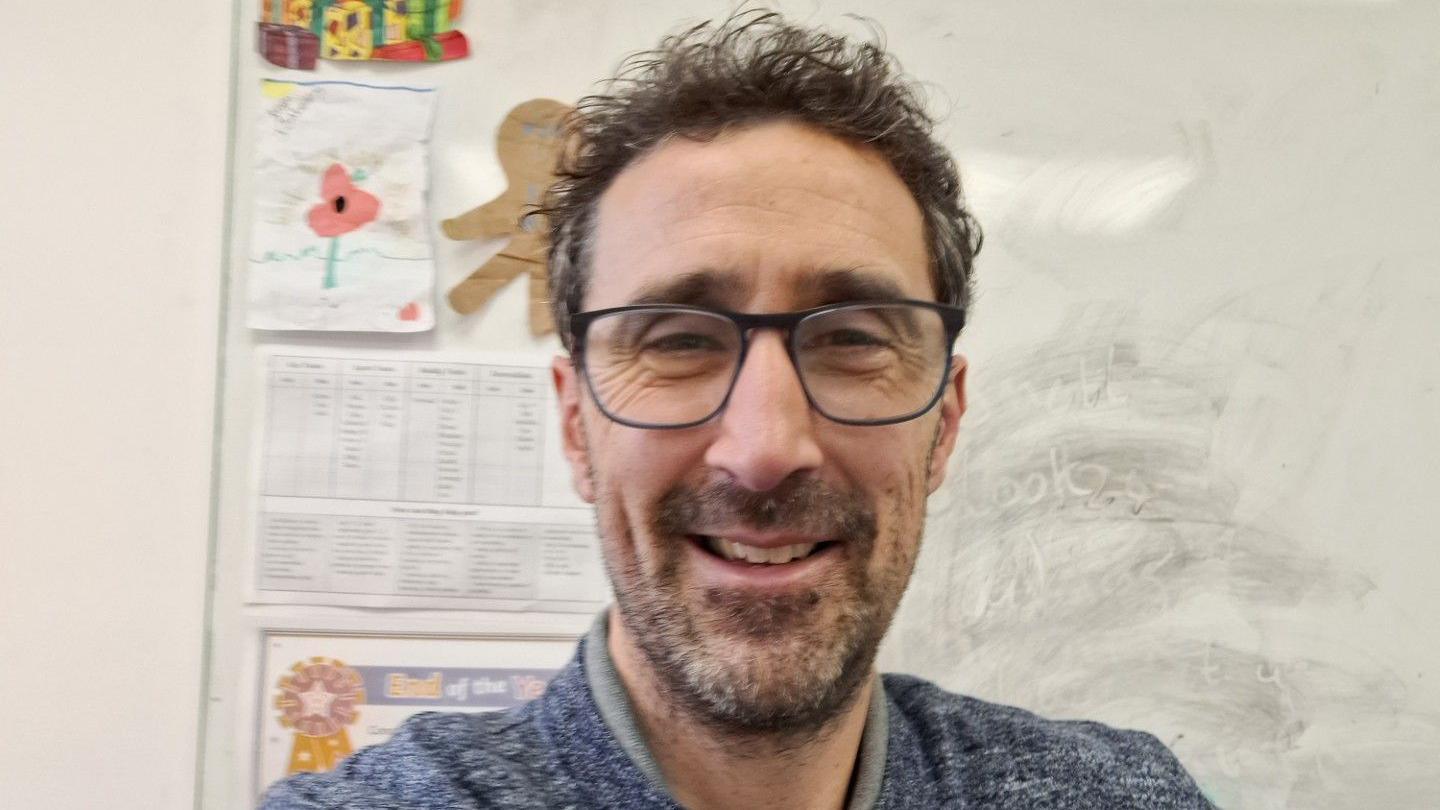 Selfie photo of headteacher Steve Hitchcock. He is wearing glasses and has black hair and a beard and is smiling