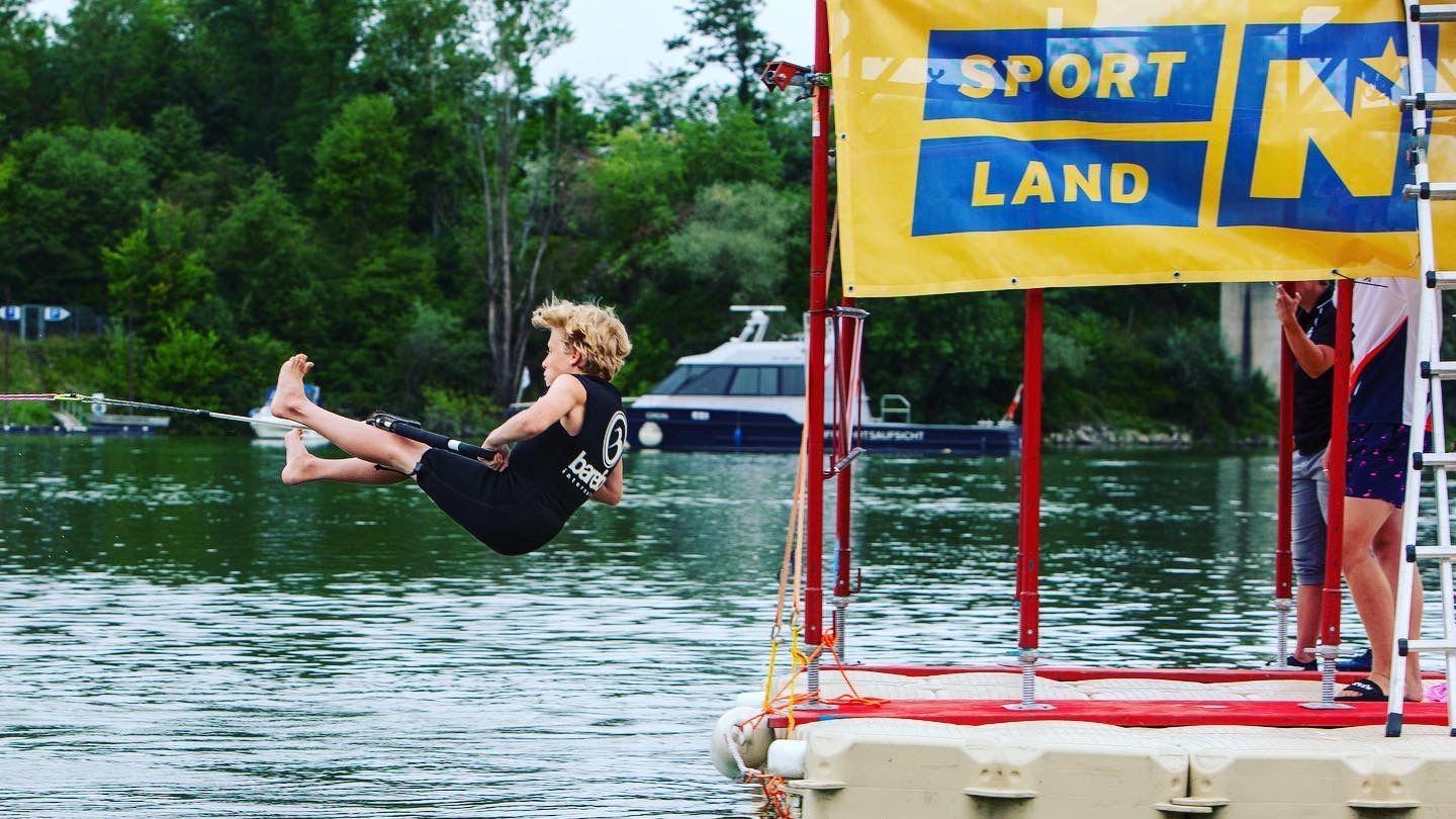 Olly Moore is pictured floating in the air as he holds onto a rope with his feet straight out in front of him