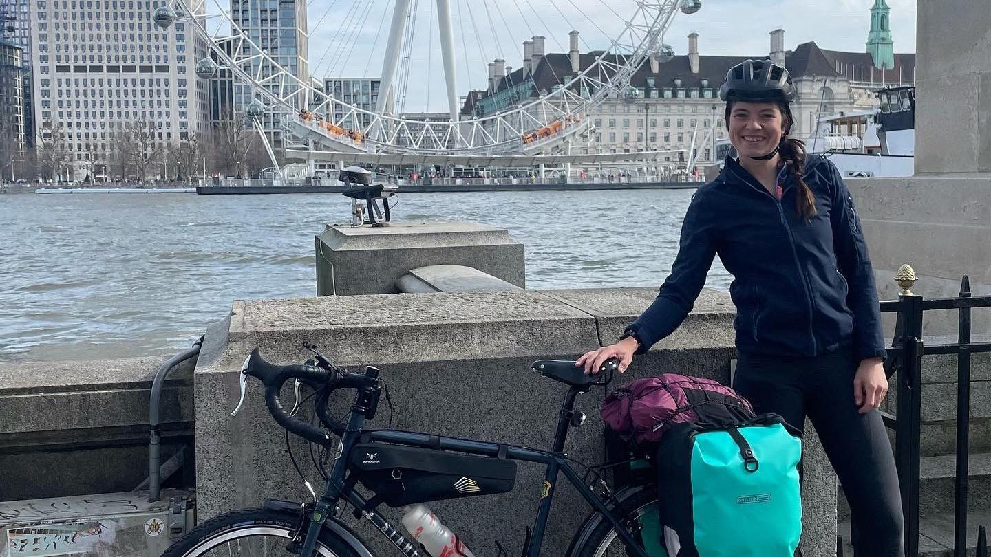 Esme Moore stood in front of the London Eye with her bike