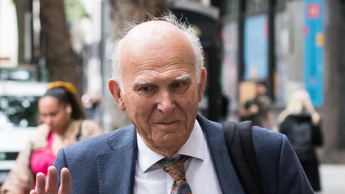 Sir Vince Cable in a blue suit with a colourful patterned tie photographed in the street walking towards his evidence session for the Post Office Horizon IT Inquiry