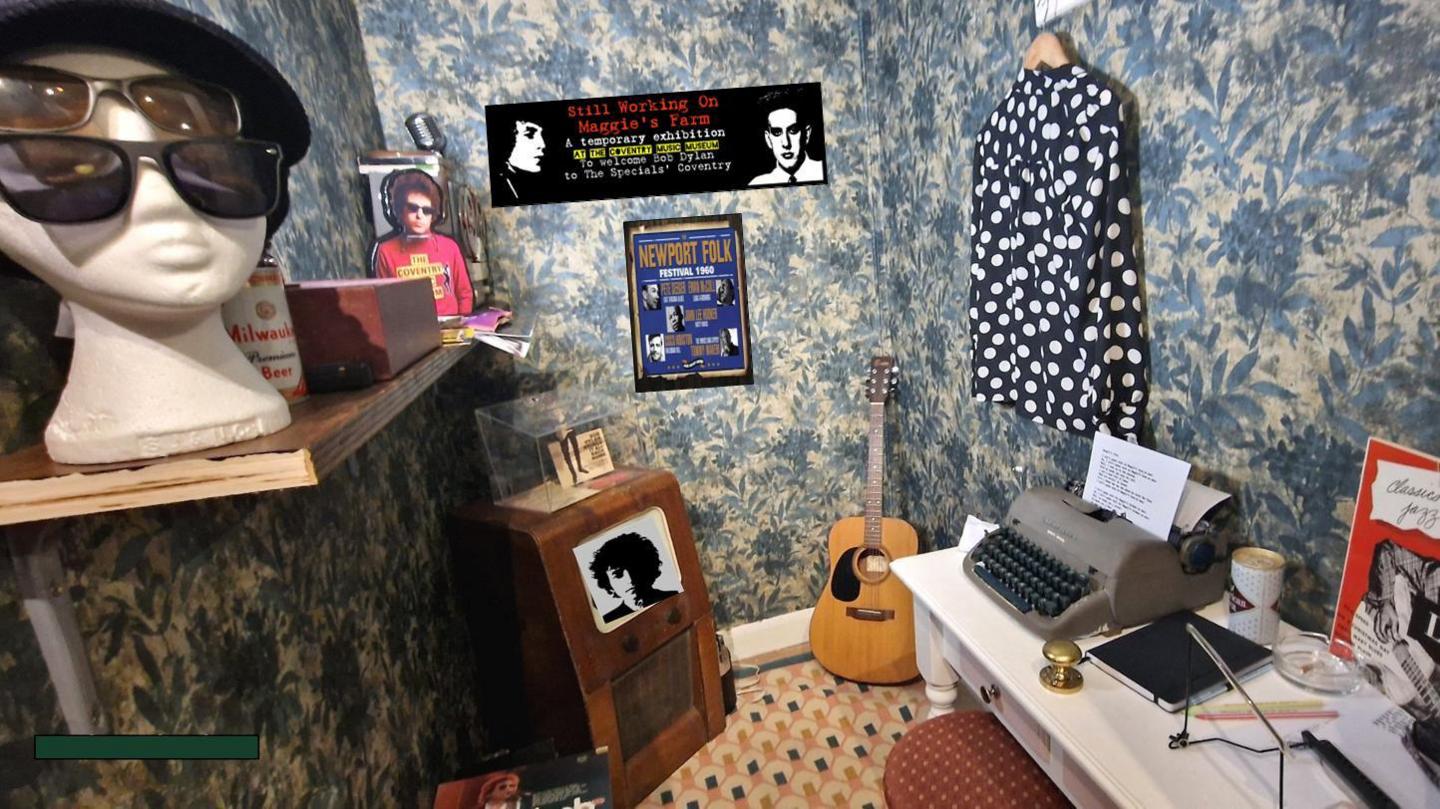 A 60s style-room with a guitar and pictures of Bob Dylan