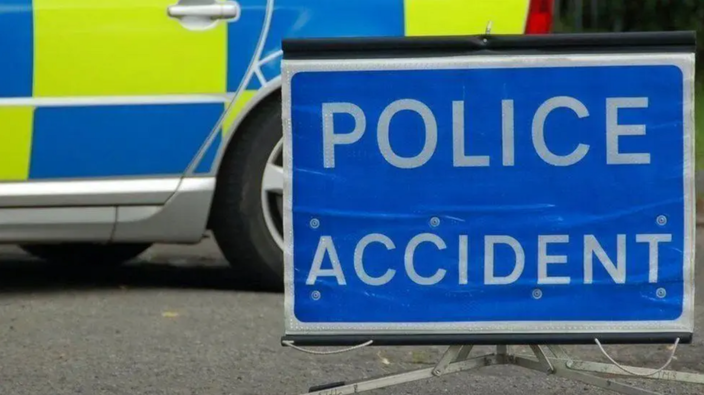 A Police Accident sign in front of a police a car. 