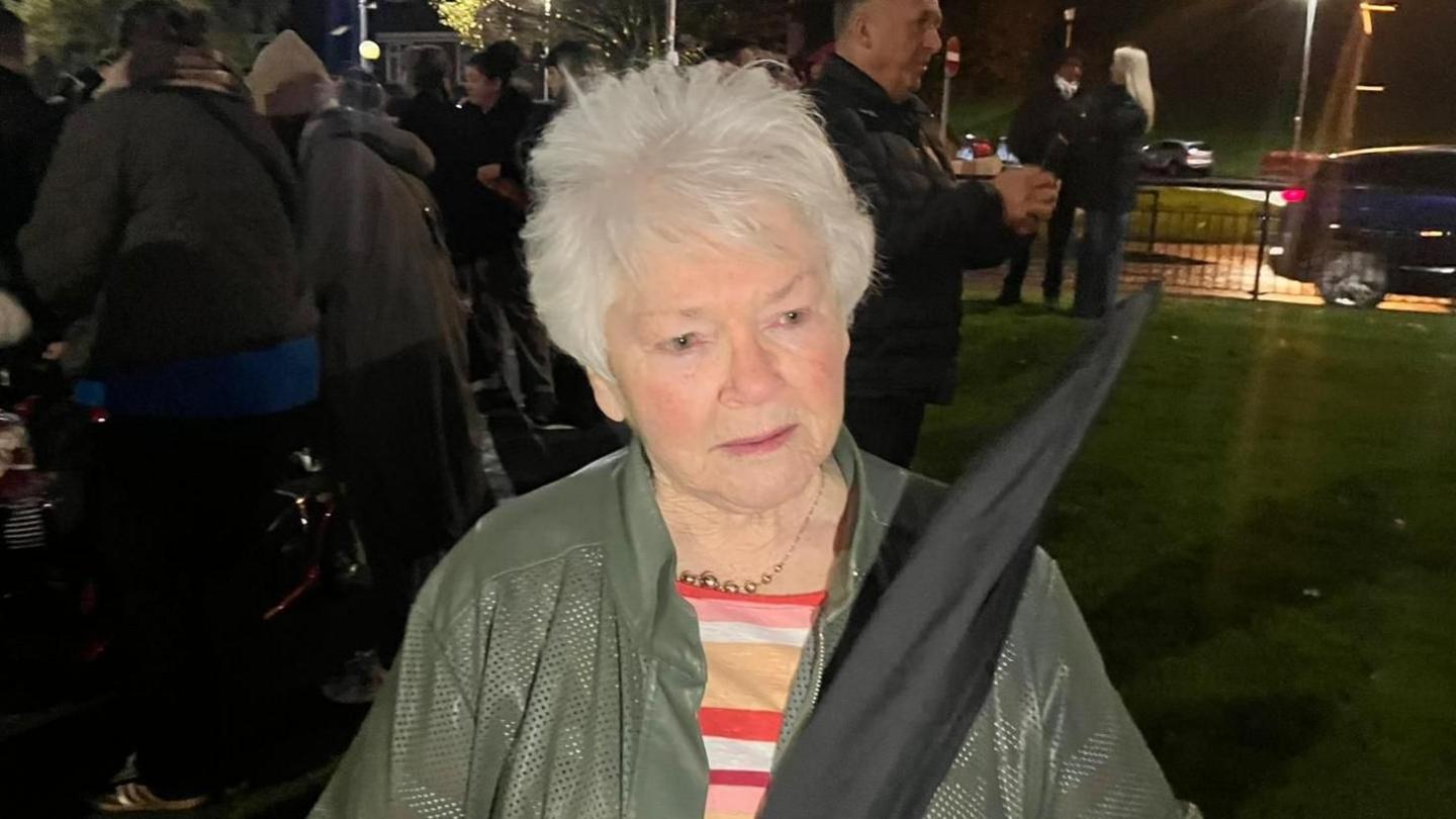 Kate Nash, a woman with grey hair, wearing a green jacket.