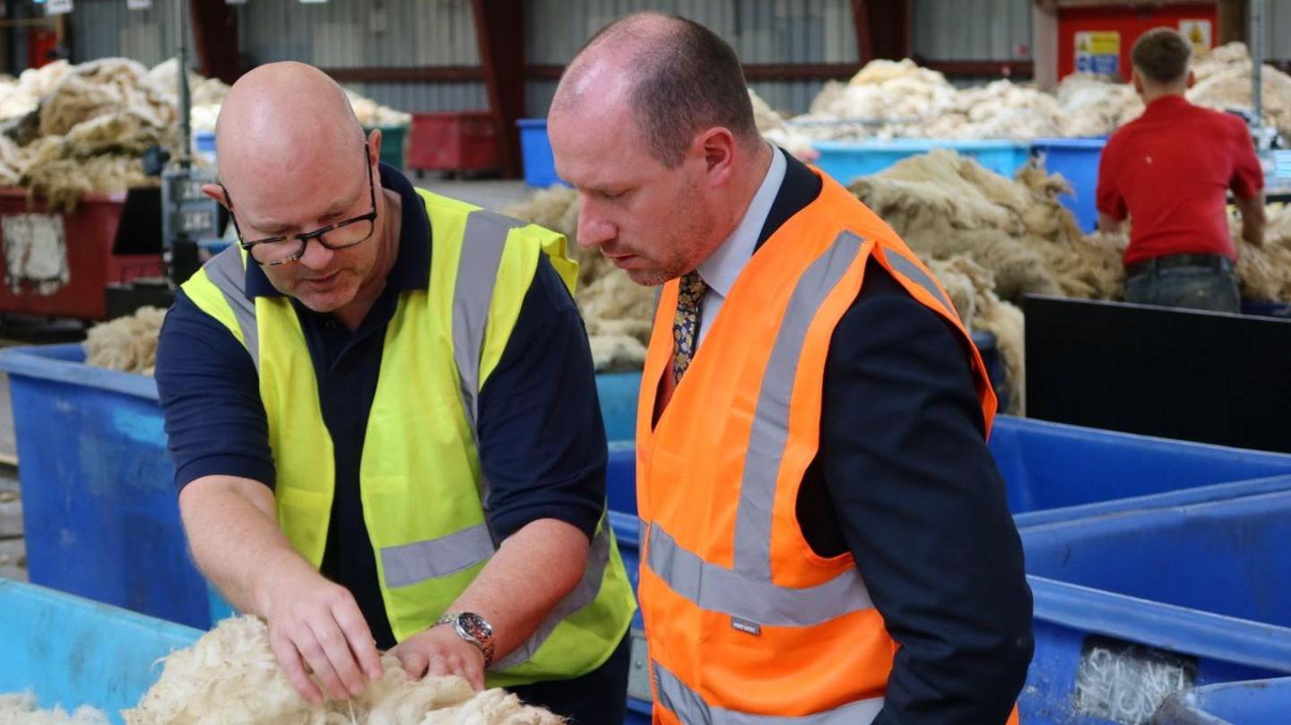 Two men checking a fleece in Selkirk