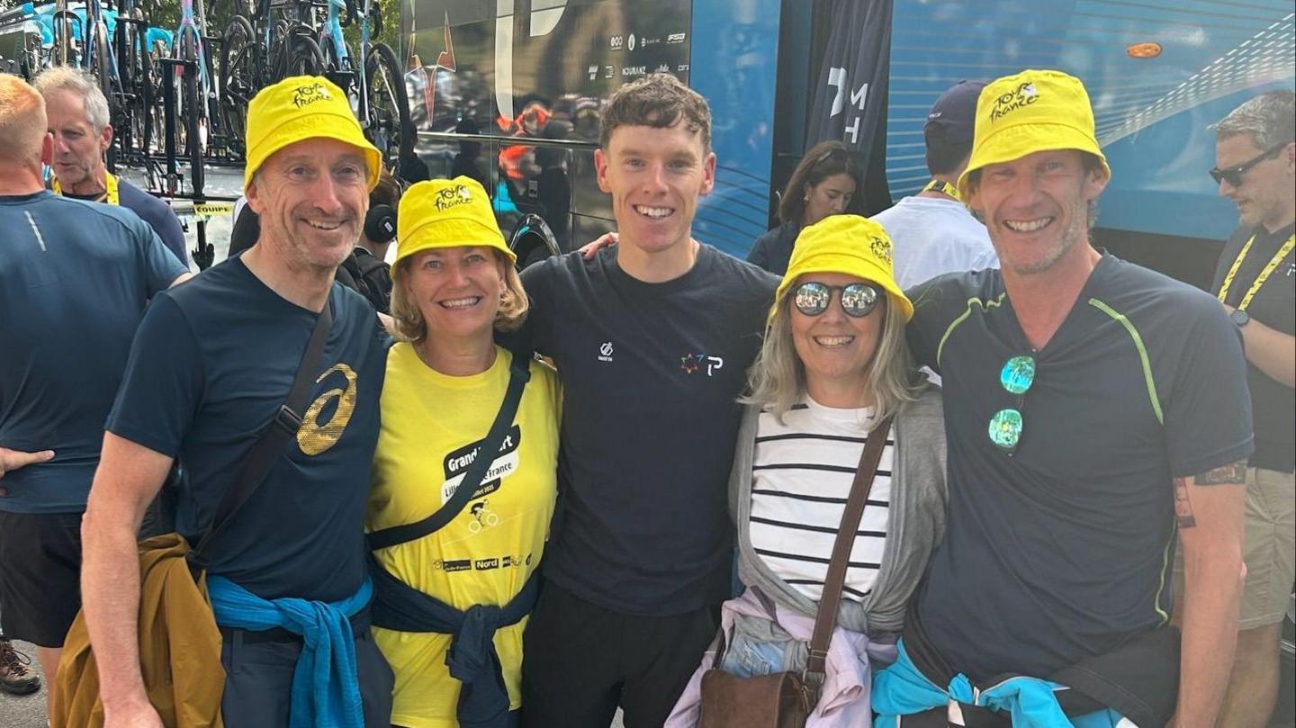 Jake Stewart with his family. Jake is in the centre with two men and two women on either side of him. They are all looking at the camera and smiling