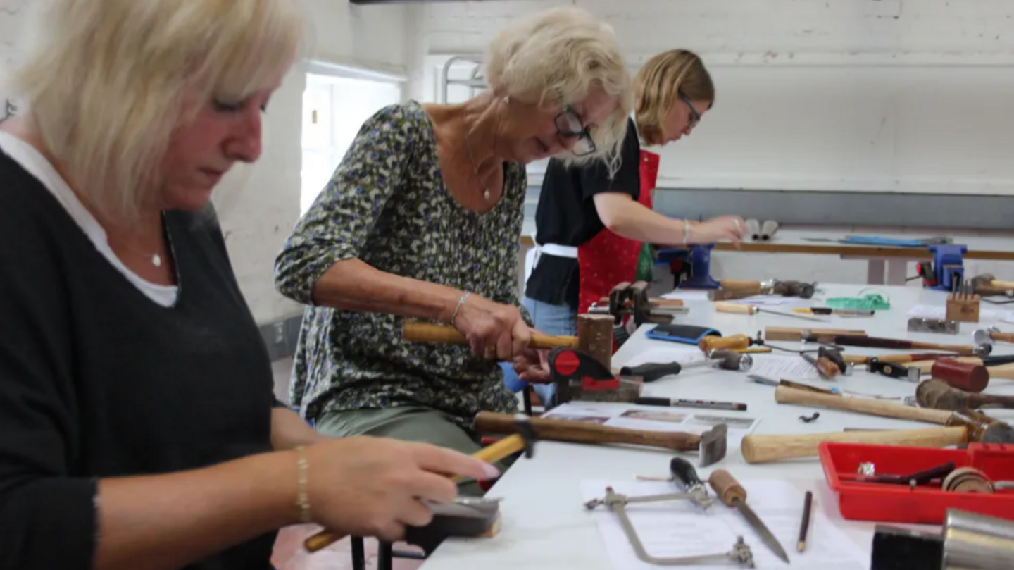 Three women in a craft workshop working away