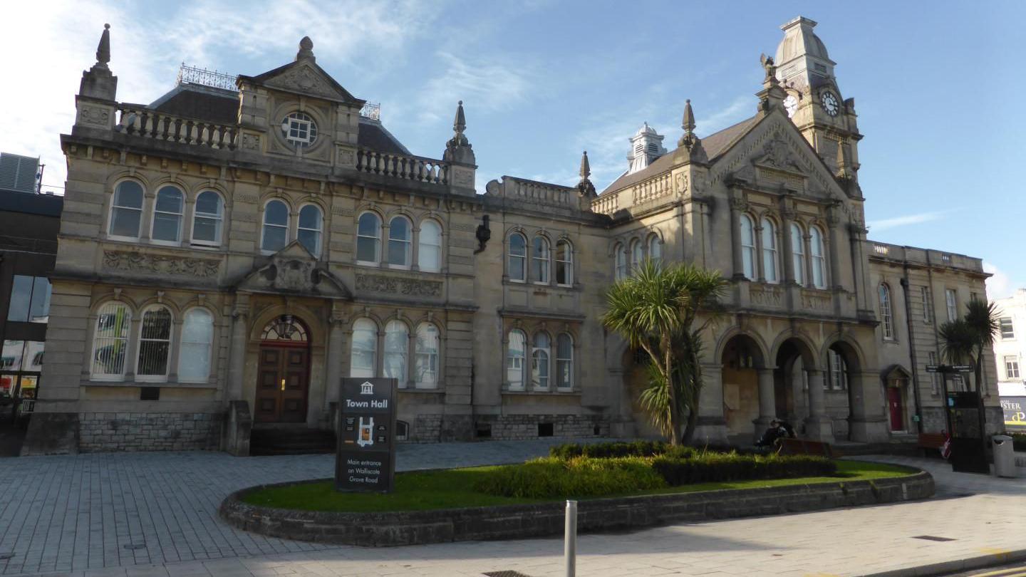 The exterior of North Somerset Council town hall. There is a sign that says 'town hall' and a small palm tree.