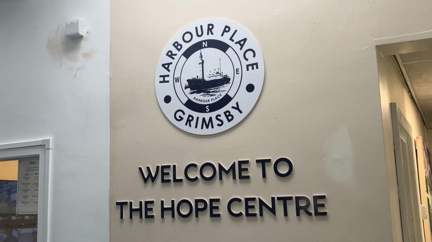 A sign that reads "welcome to the Hope Centre" with the Harbour Place Grimsby logo, on a wall inside the shelter. 