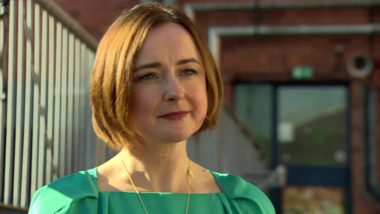 Siobhán O'Neill is looking off-camera. She has a neutral expression