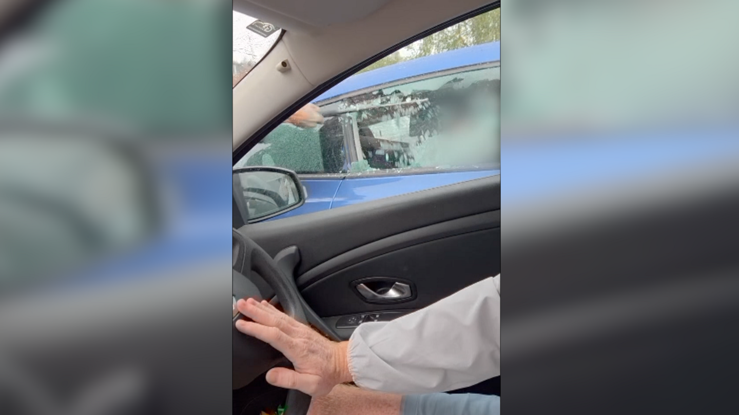 Car windscreen being broken with a police baton