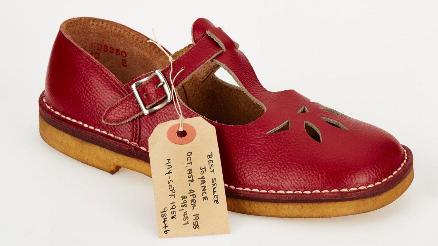 Clarks leather children's shoe. The shoe is red with a small piece of cardboard and string attached. 