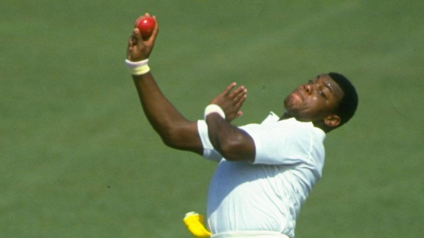 David Lawrence bowling in a cricket match with a red ball in his right hand