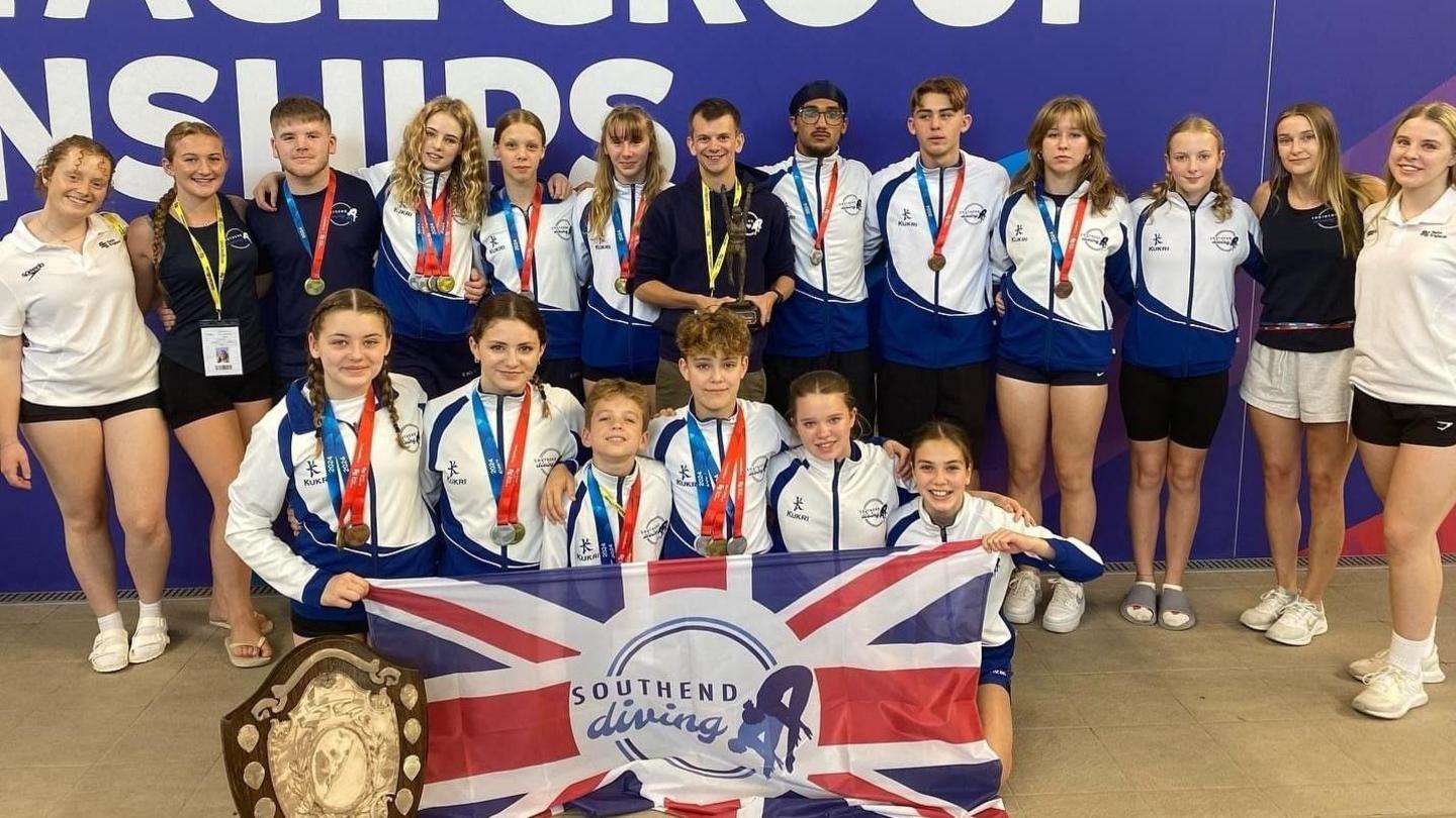 The club team with their shields and flags smiling for the camera 